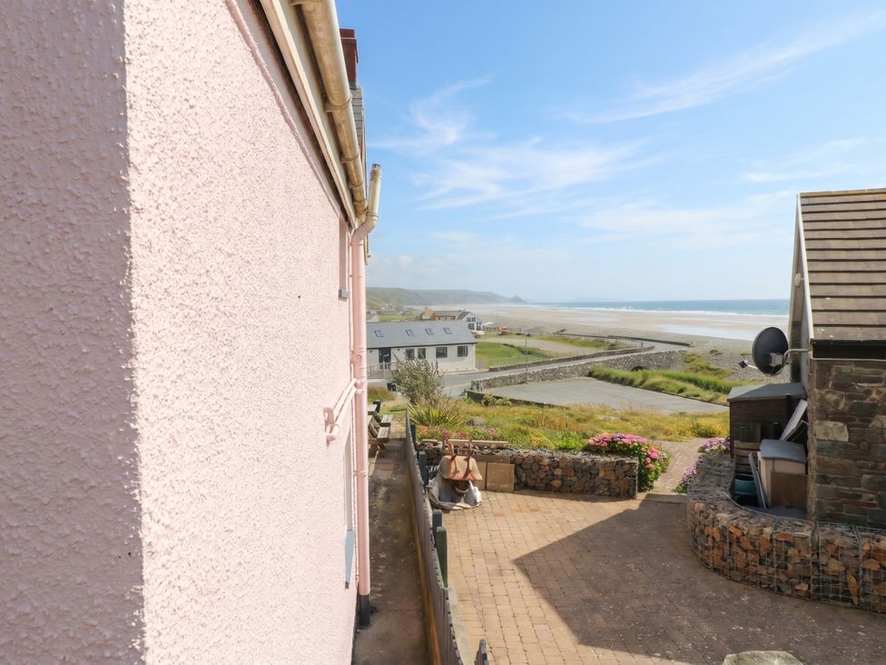An outdoor area with a pink wall and a view of the sea at Newgale Cottage in Newgale