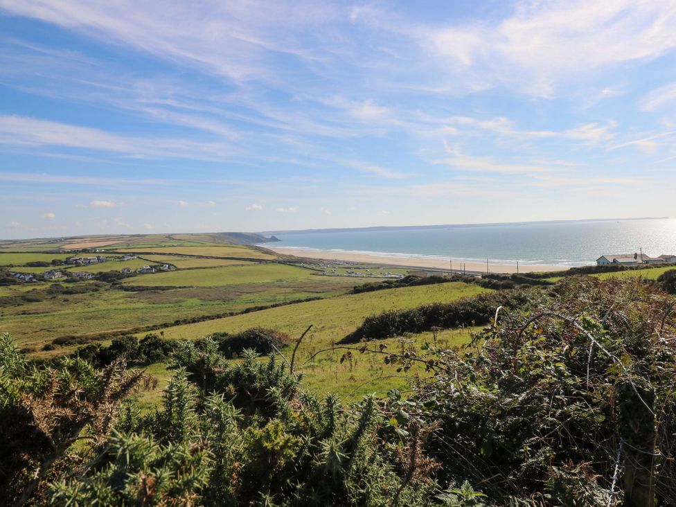 A view of the sea and sand with houses in the distance at Newgale Cottage in Newgale