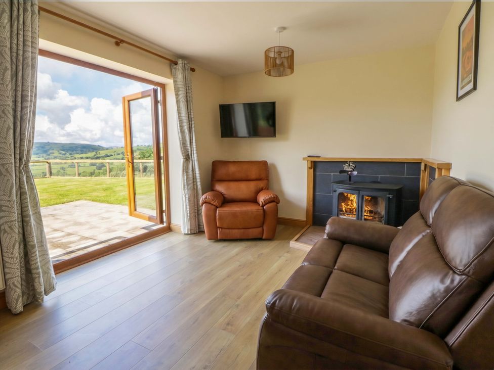 A living room with a sofa and a television at Yr Onnen