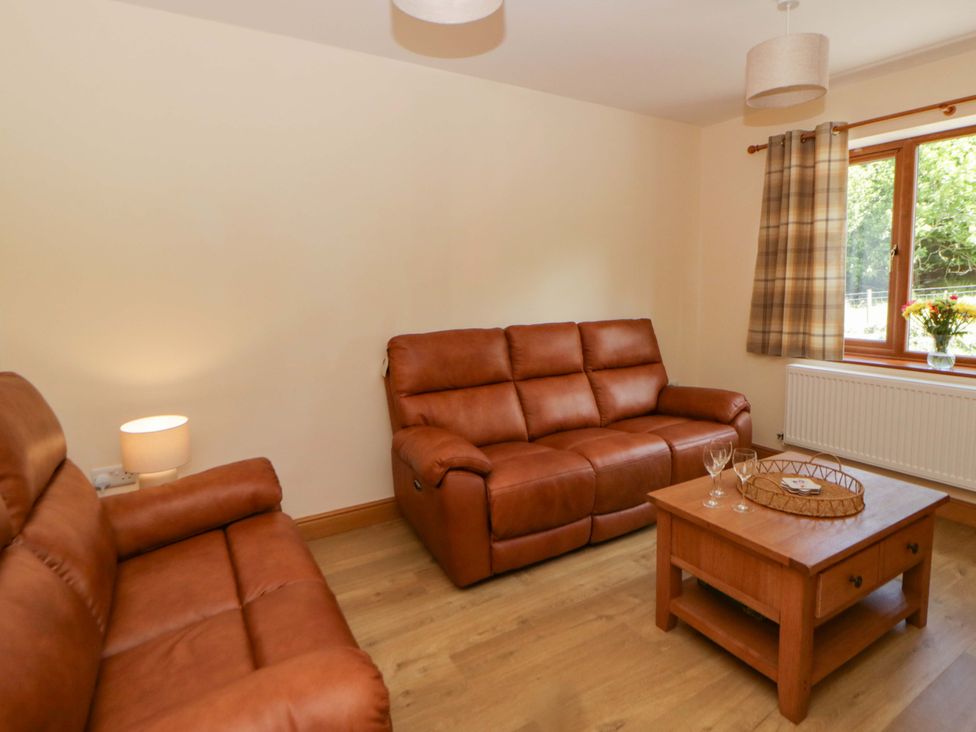 A living room with a sofa and a table at Yr Onnen