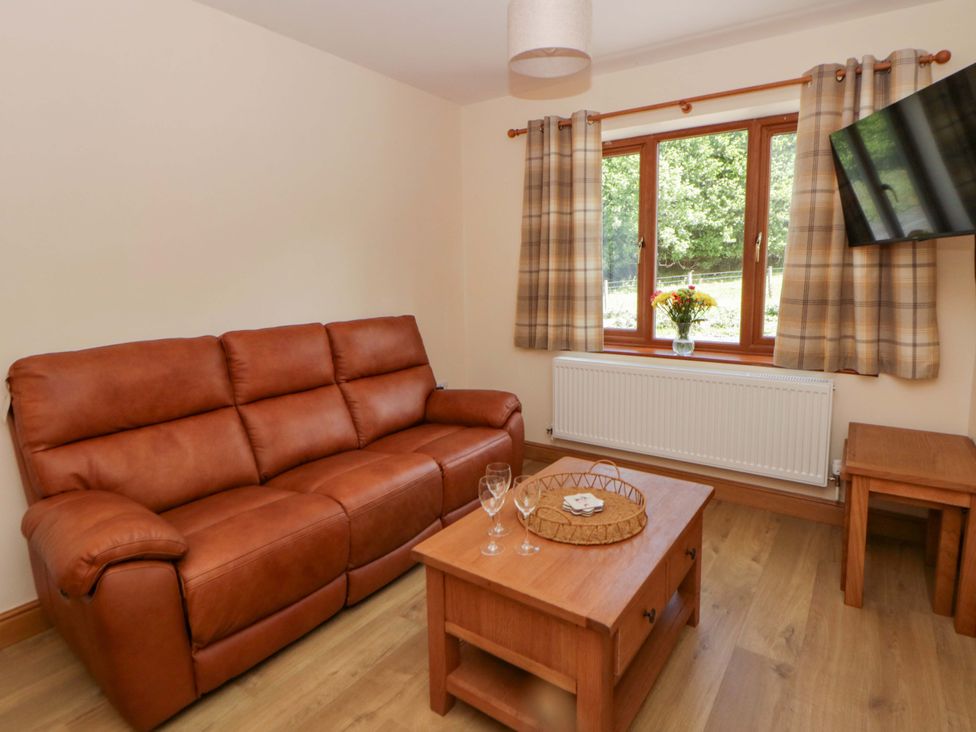 A living room with a sofa and coffee table at Yr Onnen