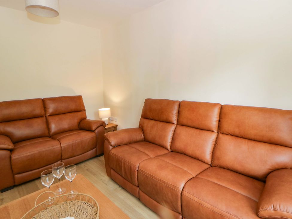 A living room with leather sofas and a coffee table at Yr Onnen