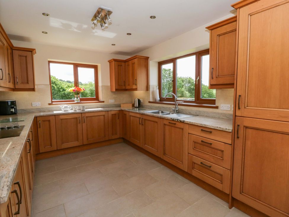 A kitchen with cabinets and a sink at Yr Onnen