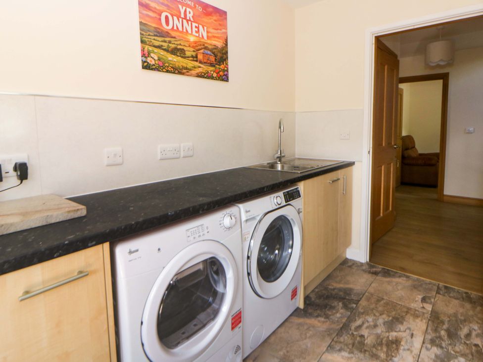 A laundry room with washing machine and dryer at Yr Onnen