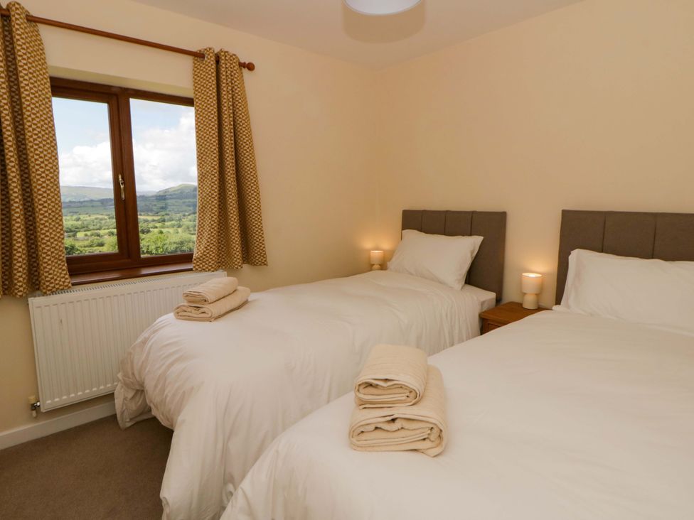 A bedroom with two beds and a window at Yr Onnen