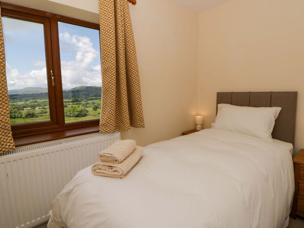 A bedroom with a single bed and window view at Yr Onnen