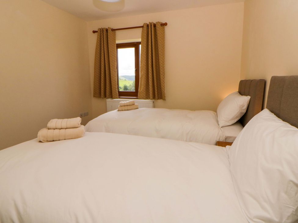 A bedroom with two beds and a window at Yr Onnen 