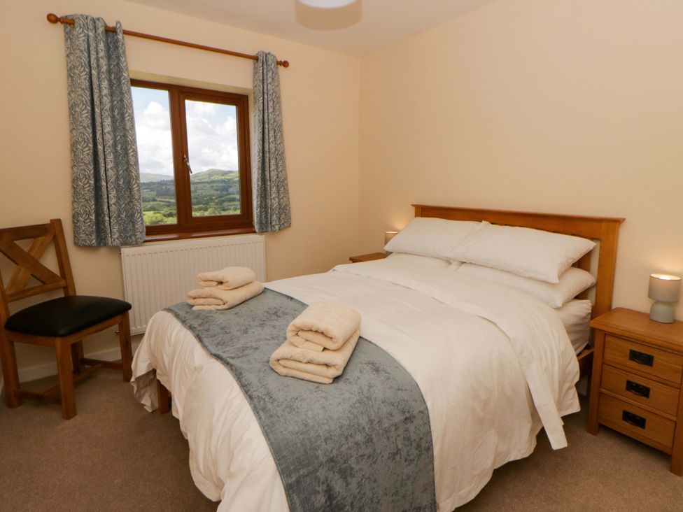 A bedroom with a bed and window at Yr Onnen