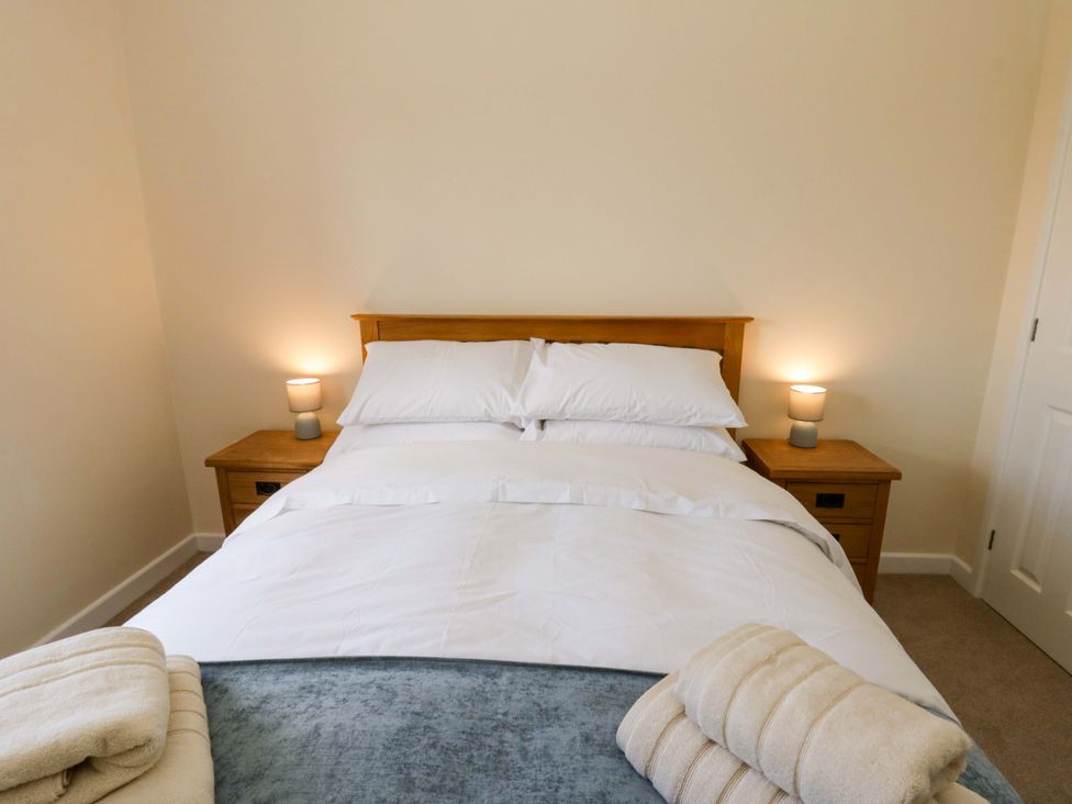 A bedroom with a bed and nightstands at Yr Onnen
