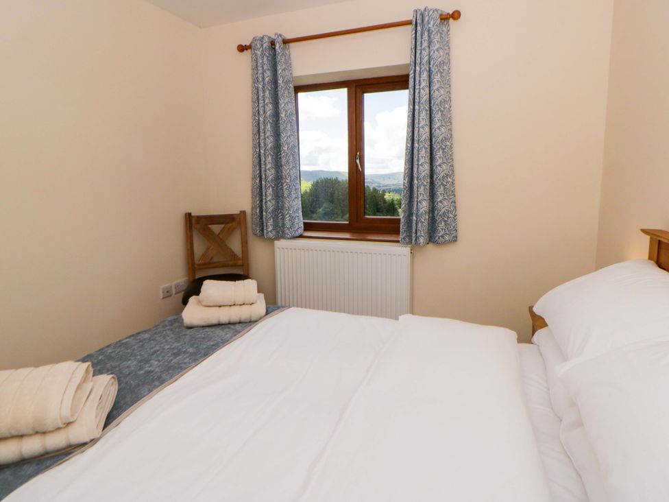 A bedroom with a bed and chair at Yr Onnen