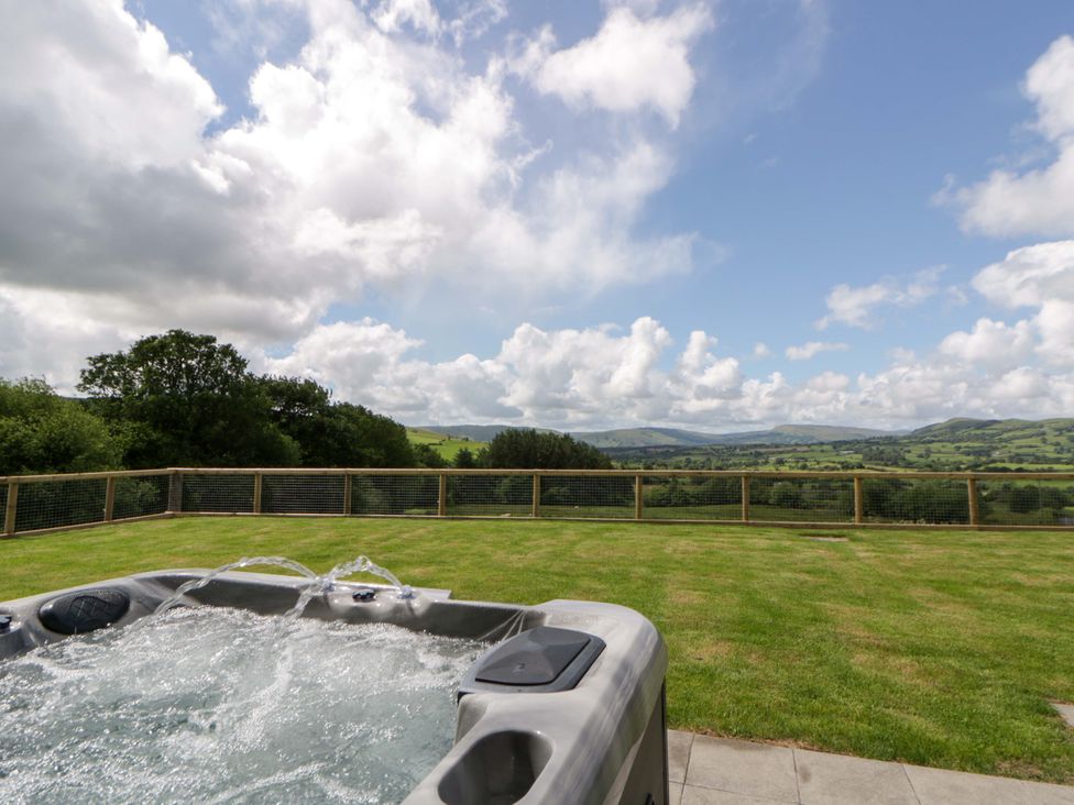 A hot tub with a view of hills at Yr Onnen