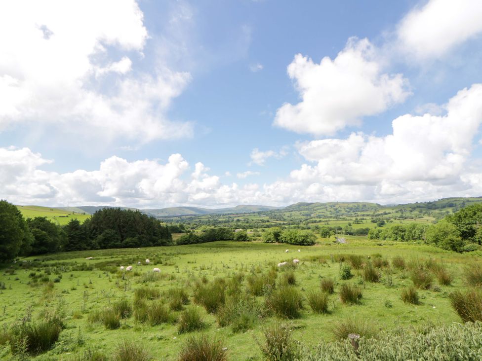 A landscape view with sheep grazing on grass at Yr Onnen in 