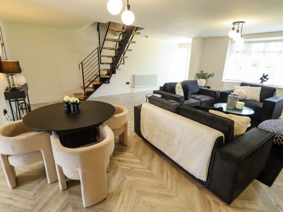 A living room with a staircase and a dining area at 21 Anderby road