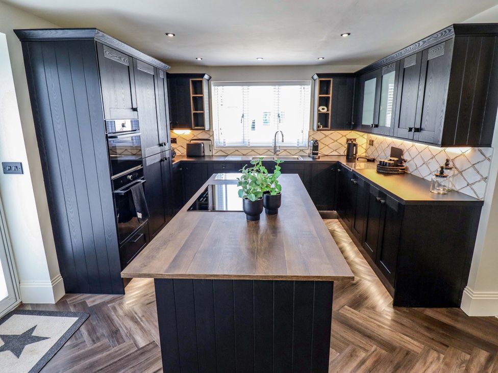 A kitchen with cabinets, countertop, sink, and window at 21 Anderby road