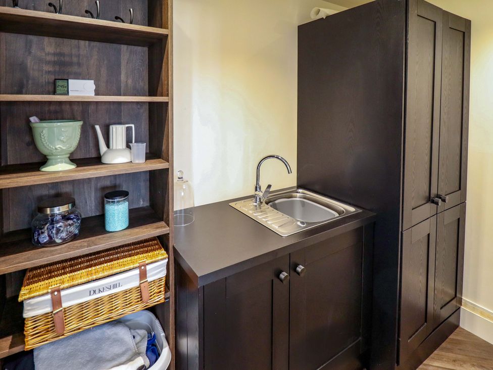 A kitchen area with a sink and shelves at 21 Anderby road