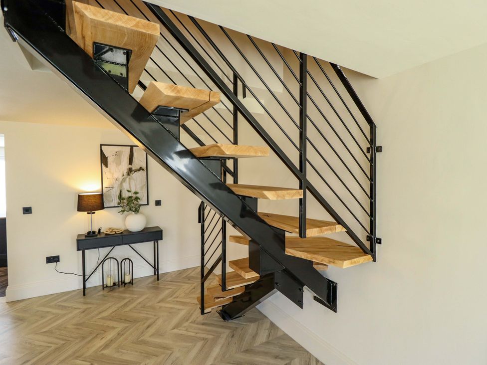 A staircase with wooden steps and a black handrail at 21 Anderby road