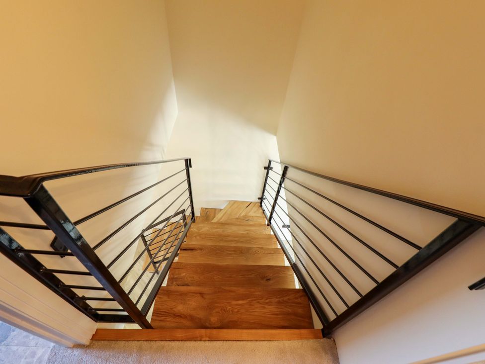 A staircase with a railing in a stairwell at 21 Anderby road