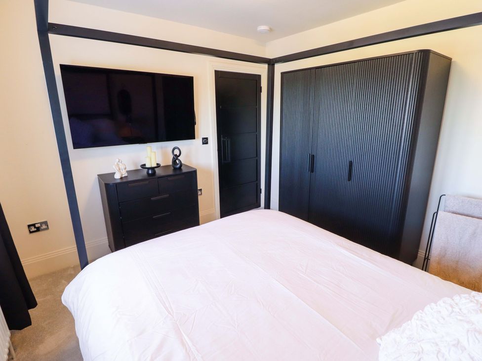 A bedroom with a bed, wardrobe, television, and chest of drawers at 21 Anderby road