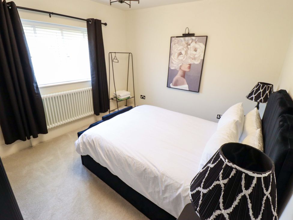 A bedroom with a bed, curtains, and a painting at 21 Anderby road
