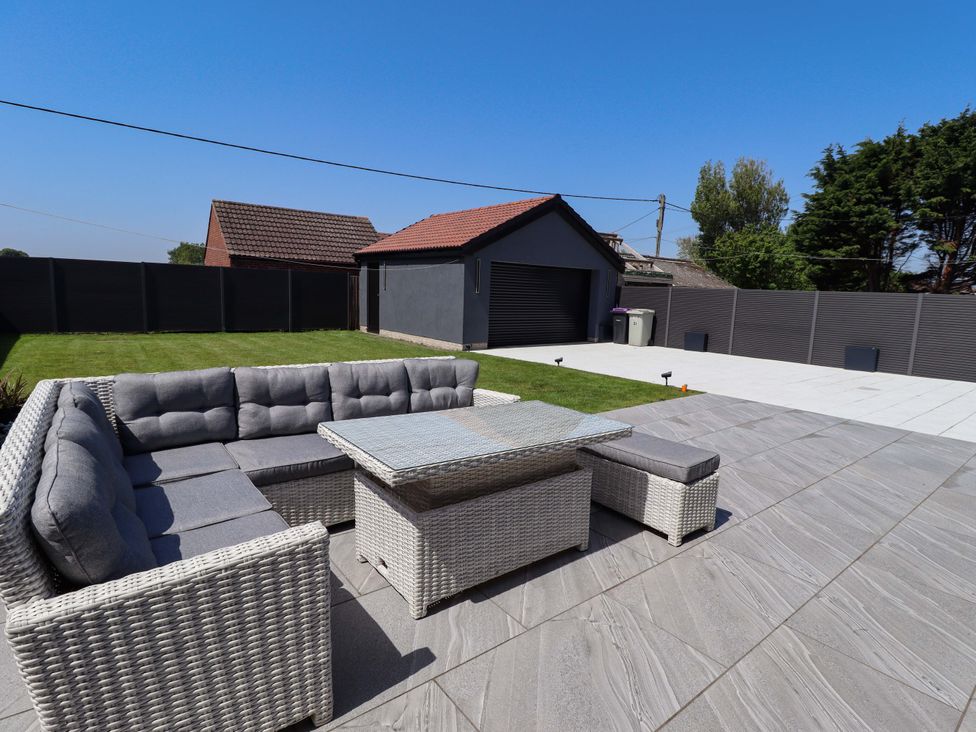 A garden with outdoor seating and a garage at 21 Anderby road