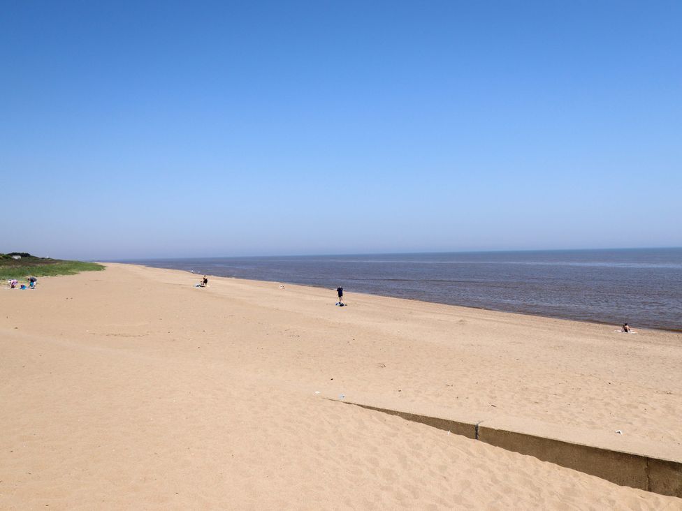 A beach with sand and people near the water at 21 Anderby road