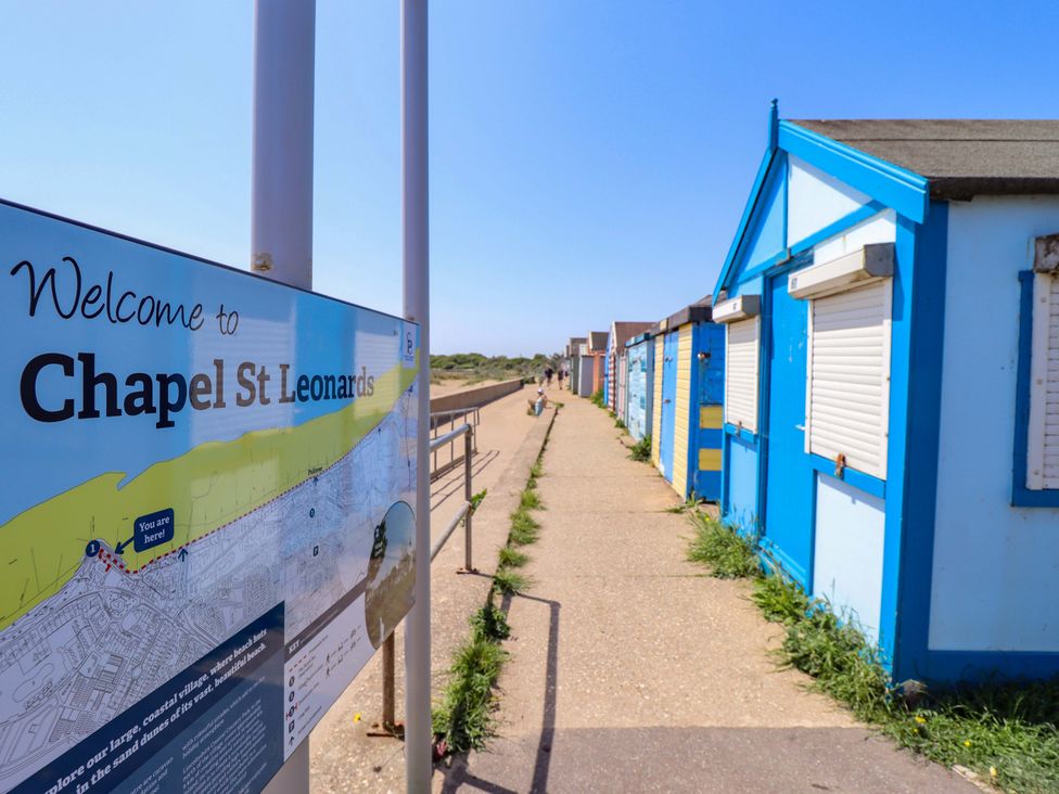 A pathway lined with beach huts at Chapel St Leonards