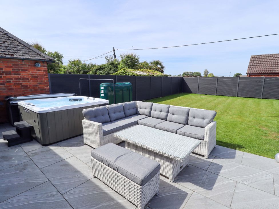 A garden with a hot tub and seating area at 21 Anderby Road, Chapel St Leonards