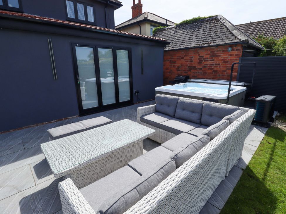 An outdoor living area with a sofa and coffee table at 21 Anderby Road in Chapel St Leonards
