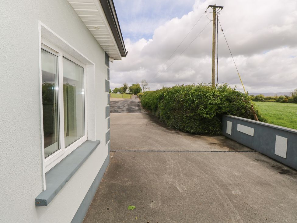 A view of a house with a window and road leading to a field at River House