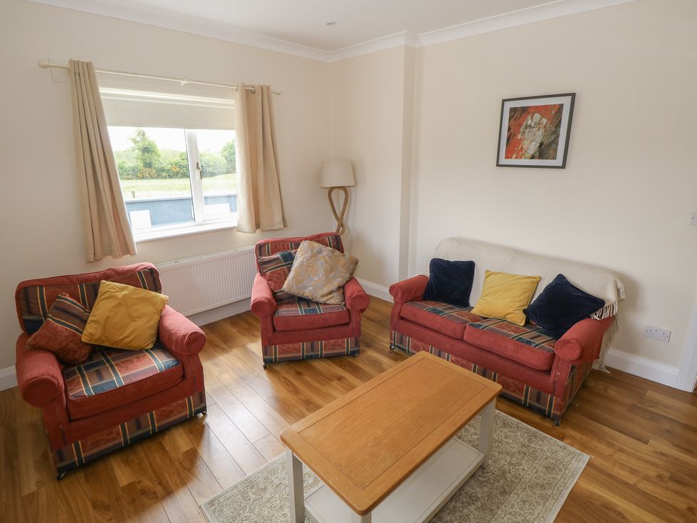 A living room with a sofa and armchairs at River House