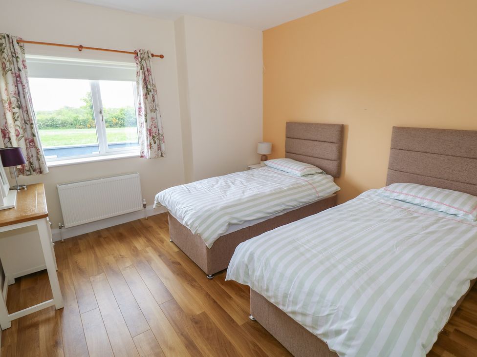 A bedroom with twin beds and a desk at River House