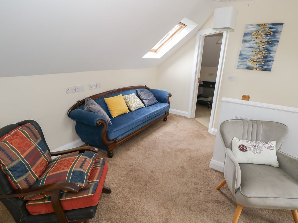 A snug with a blue sofa and two chairs at River House