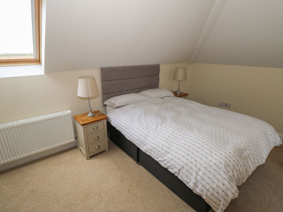 A bedroom with a bed and bedside table at River House