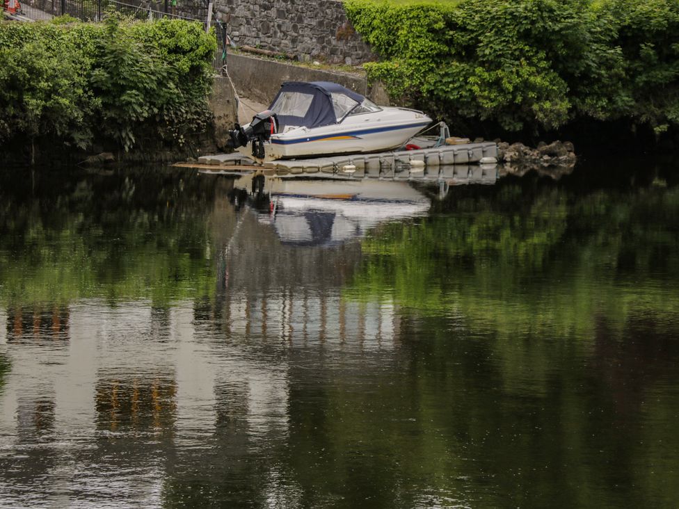 A boat docked on calm water at River House