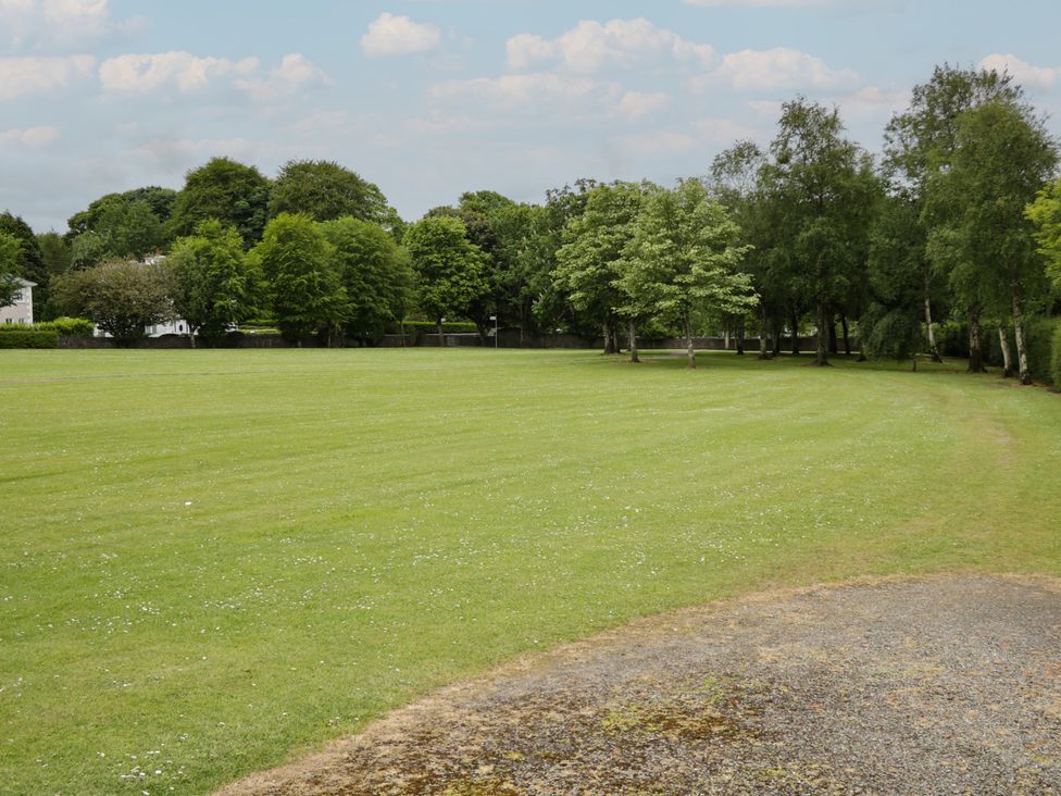 A grassy area with trees and a path at River House in 