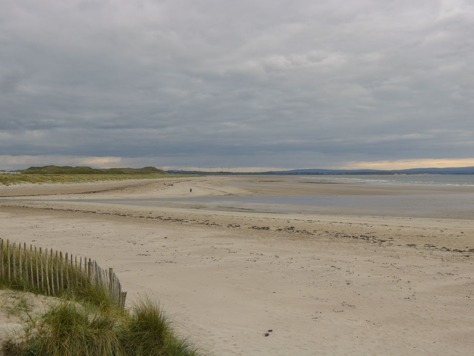 A beach with sand and water in the distance at River House