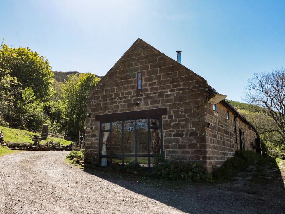A stone building with a pathway and trees at The Cottage in Stokesley