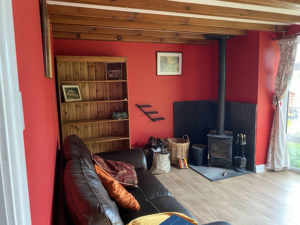 A living room with a sofa and wood stove at The Cottage Stokesley