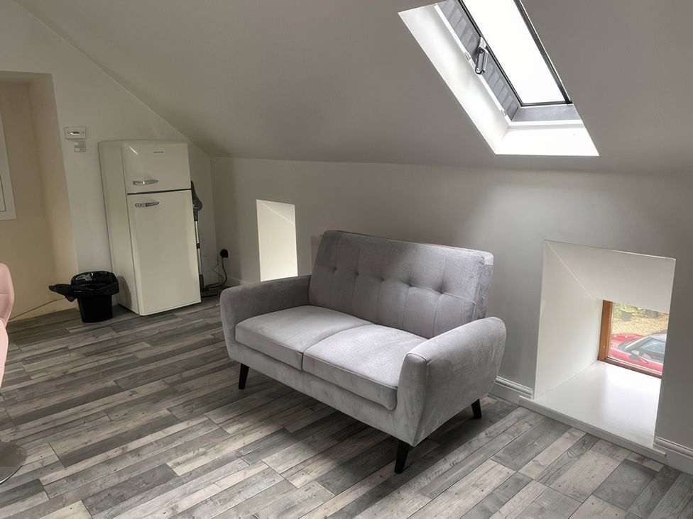 A living room with a sofa and refrigerator at The Cottage Stokesley