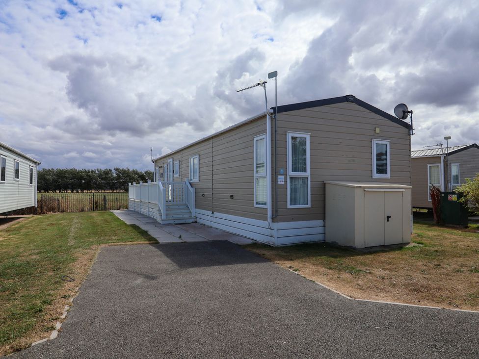 A caravan with steps and a satellite dish at Caravan i35 Towyn