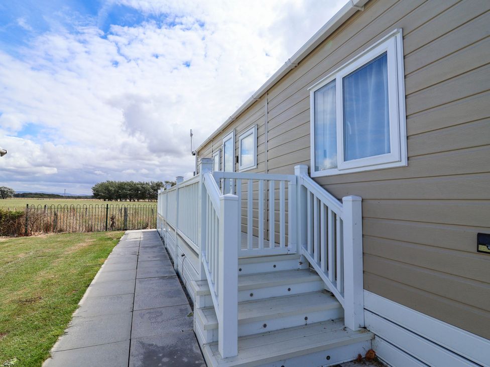 A caravan exterior with steps and grass at Caravan i35 in Towyn