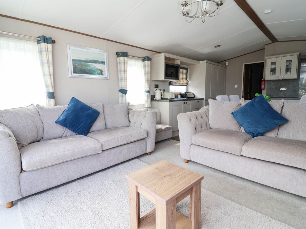 A living room with sofas and a coffee table at Caravan i35 Towyn