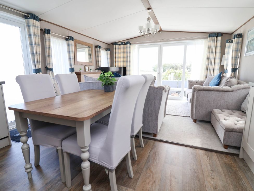 A dining room with a table and chairs at Caravan i35 in Towyn