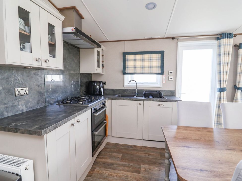 A kitchen with a stove and sink at Caravan i35 Towyn