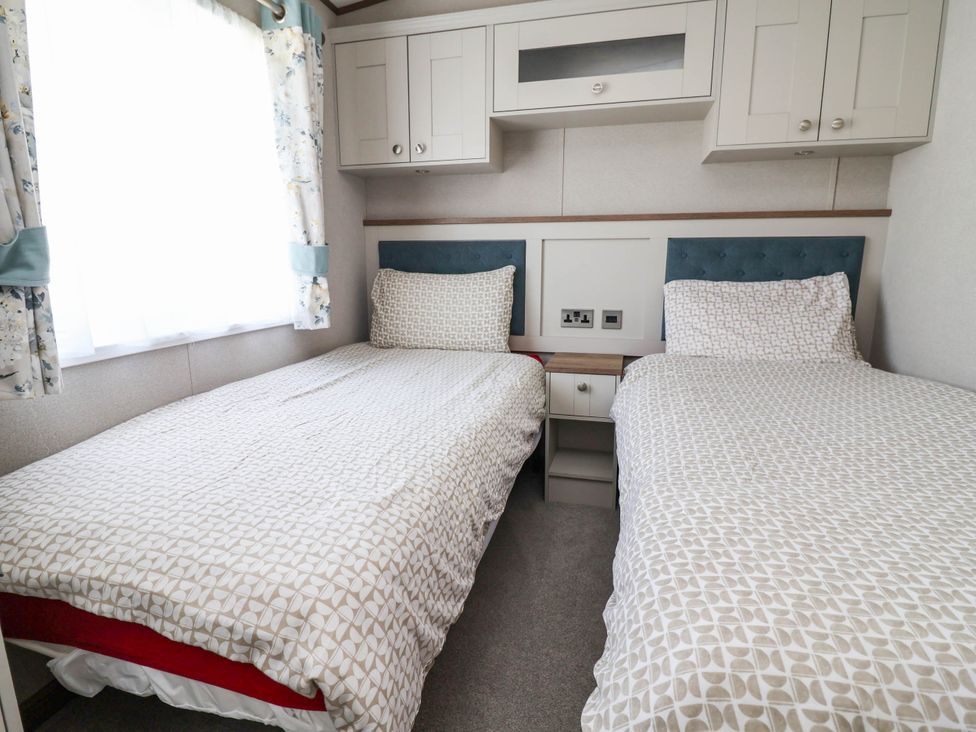A bedroom with two single beds at Caravan i35 in Towyn