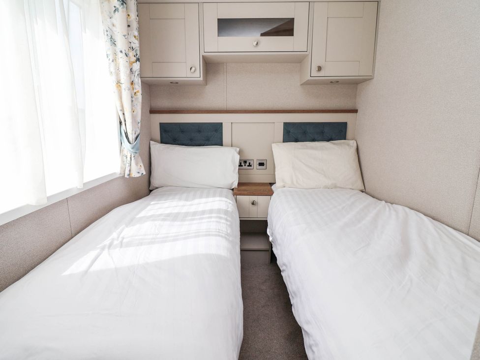 A bedroom with two beds and a window at Caravan i35 in Towyn