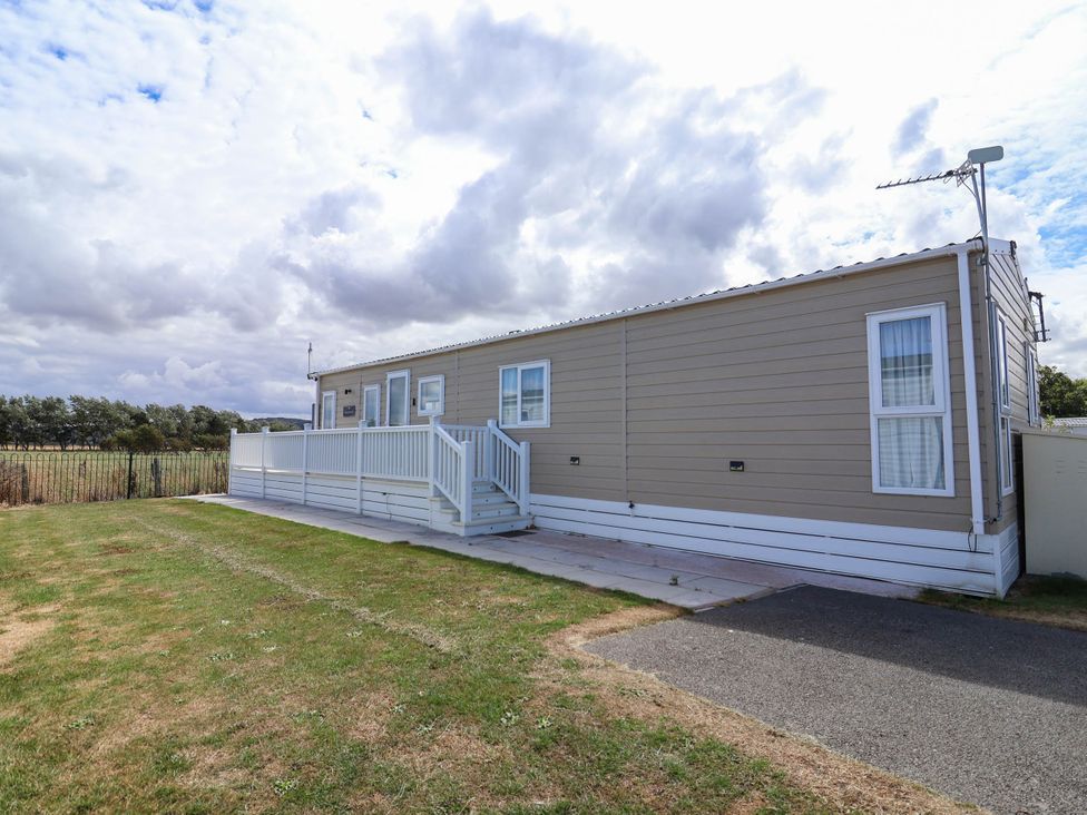 A caravan with a deck and steps at Caravan i35 Towyn