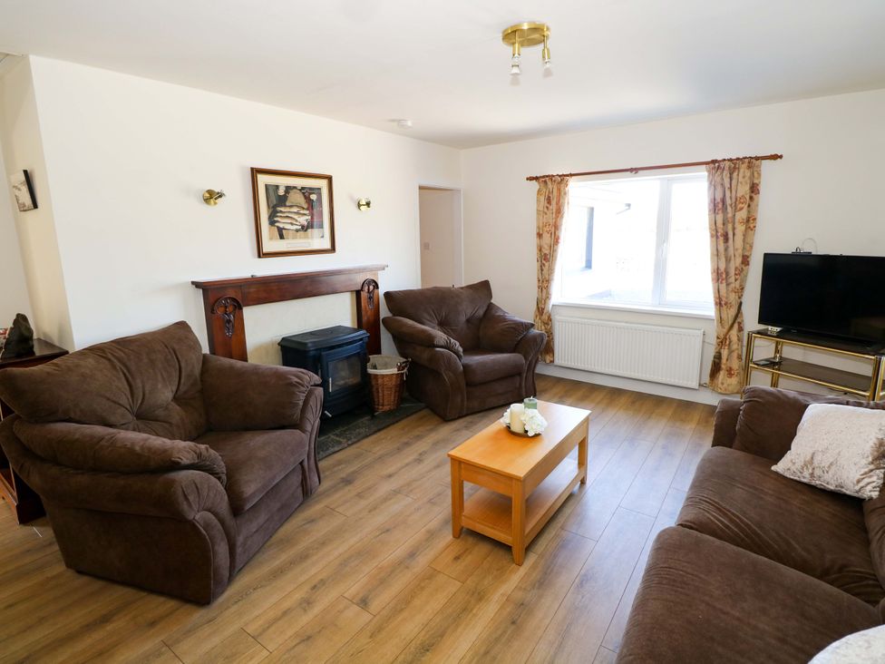 A living room with a sofa, coffee table, and fireplace at Cahir Cottage in Ballinrobe, County Mayo