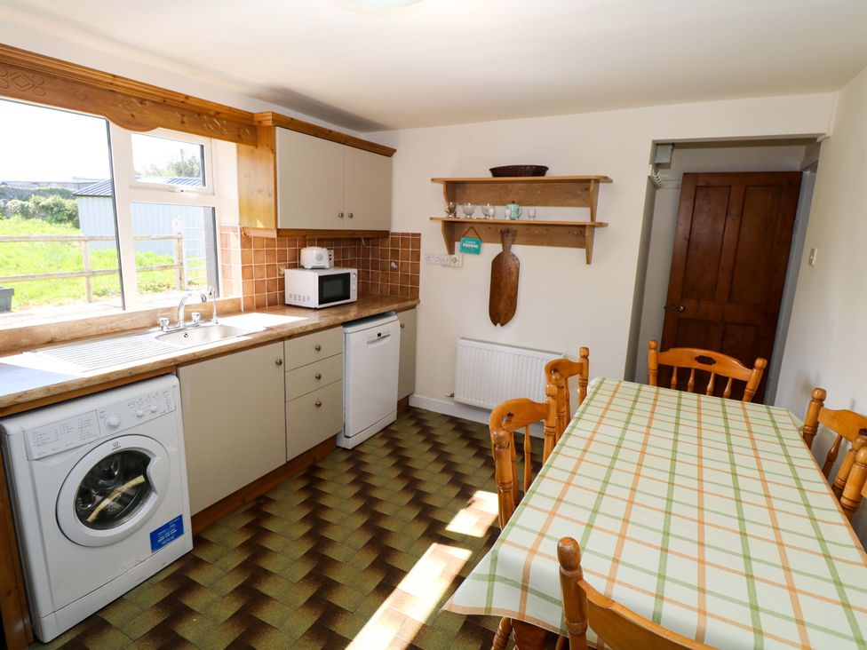 A kitchen with a sink and washing machine at Cahir Cottage Ballinrobe, County Mayo