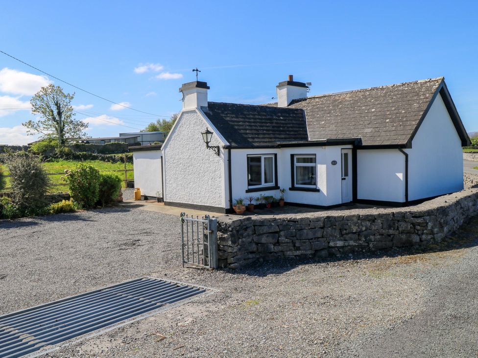 A cottage with a driveway and gate at Cahir Cottage Ballinrobe, County Mayo